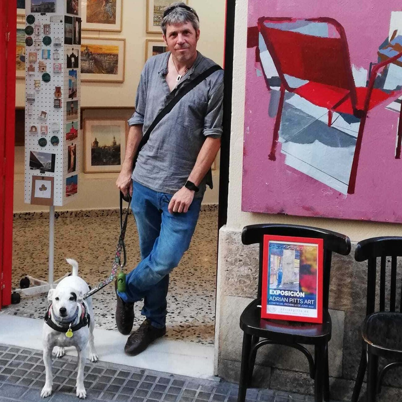 La imagen muestra una fotografía de Adrian Pitts (venta de cuadros particulares) en una galería de arte.